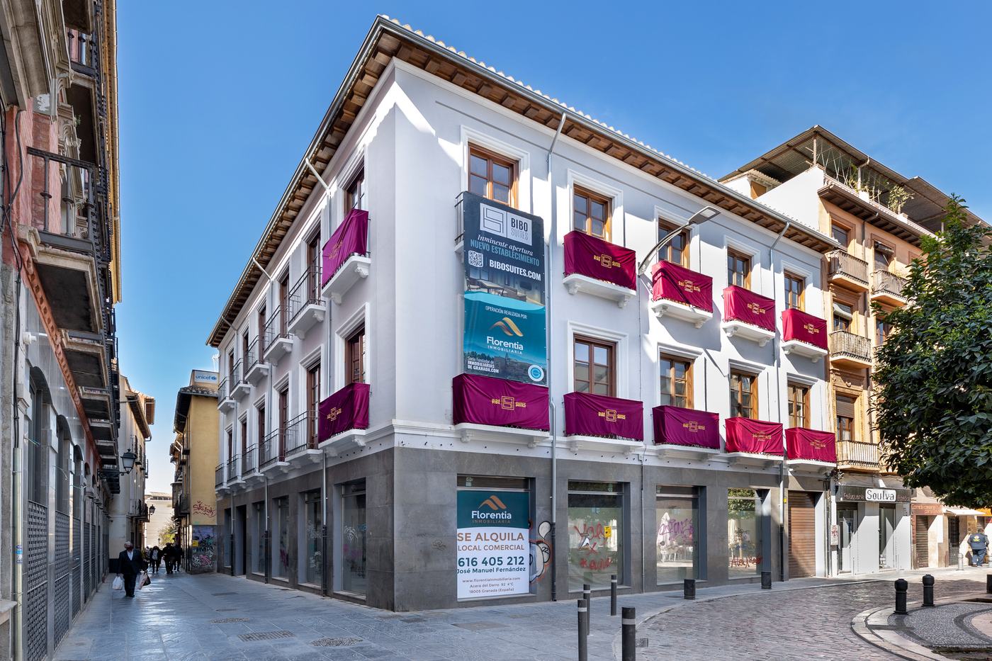 Edificio rehabilitado en la esquina de Calle Mercaderes, en el centro de Granada, con el cartel de Florentia Inmobiliaria en la fachada